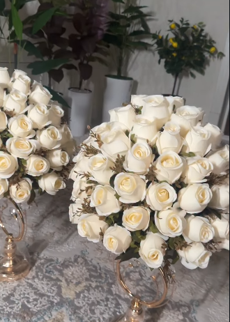 Arranjo decorativo de rosas brancas com suporte dourado